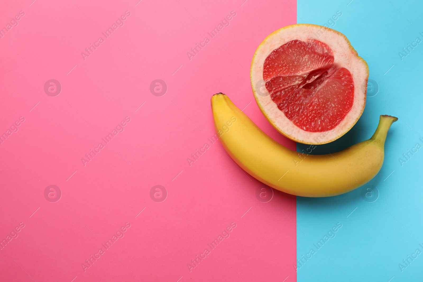 Photo of Banana and half of grapefruit on color background, flat lay with space for text. Sex concept