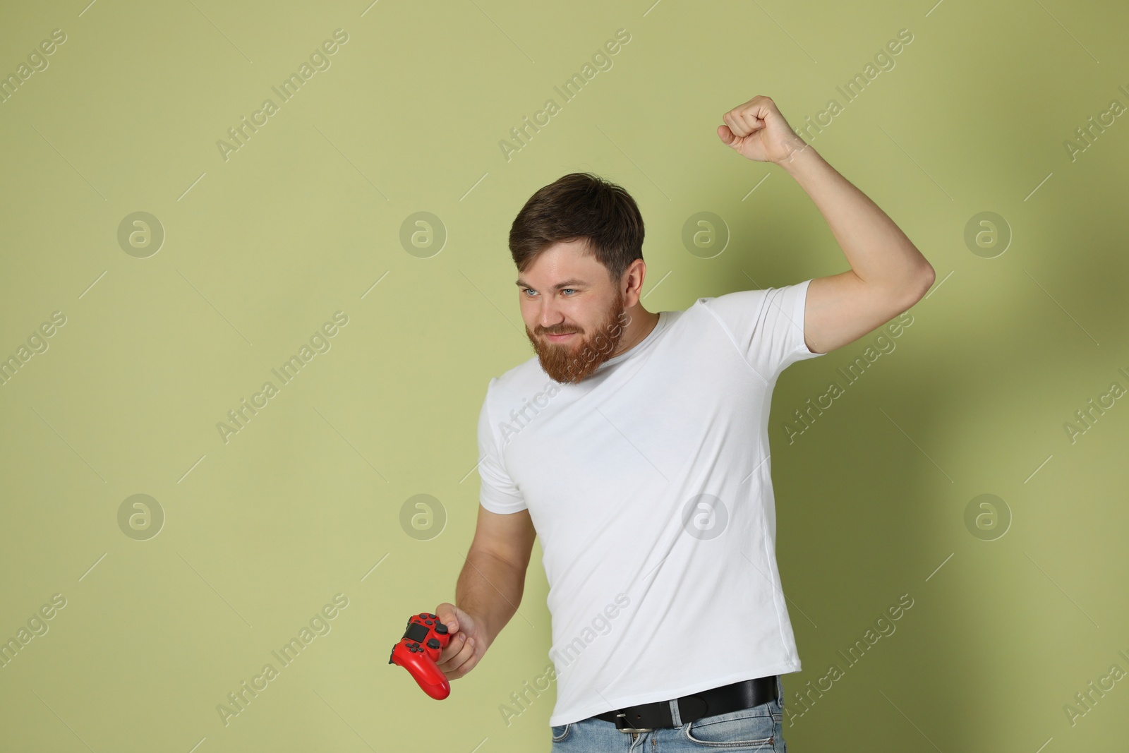 Photo of Young man with game controller on pale green background. Space for text