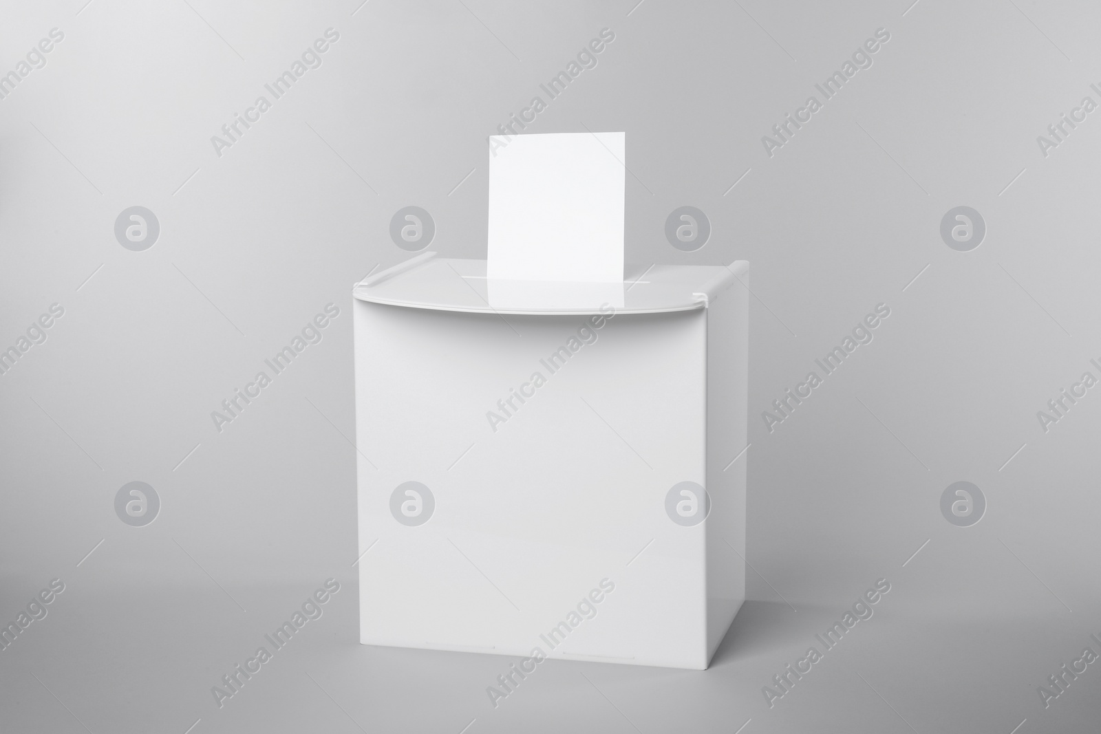 Photo of Ballot box with vote on light grey background. Election time