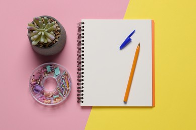 Photo of Ballpoint pen, notebook and different clips on color background, flat lay