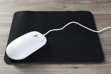 Photo of Wired mouse and mousepad on wooden table