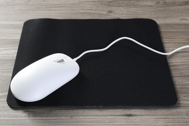 Wired mouse and mousepad on wooden table