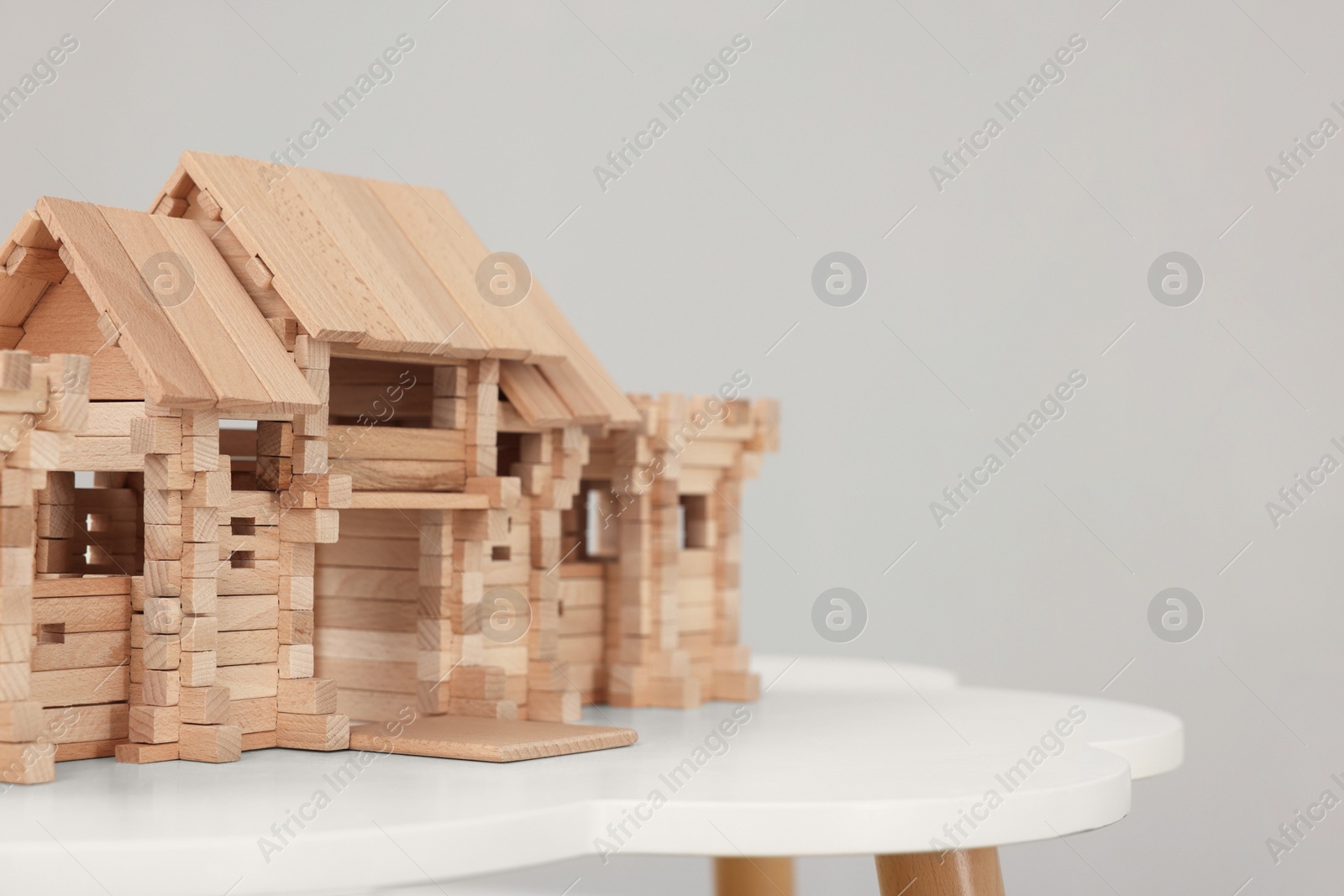 Photo of Wooden entry gate on table against light background, space for text. Children's toy