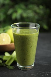 Photo of Delicious fresh green juice on black table, closeup