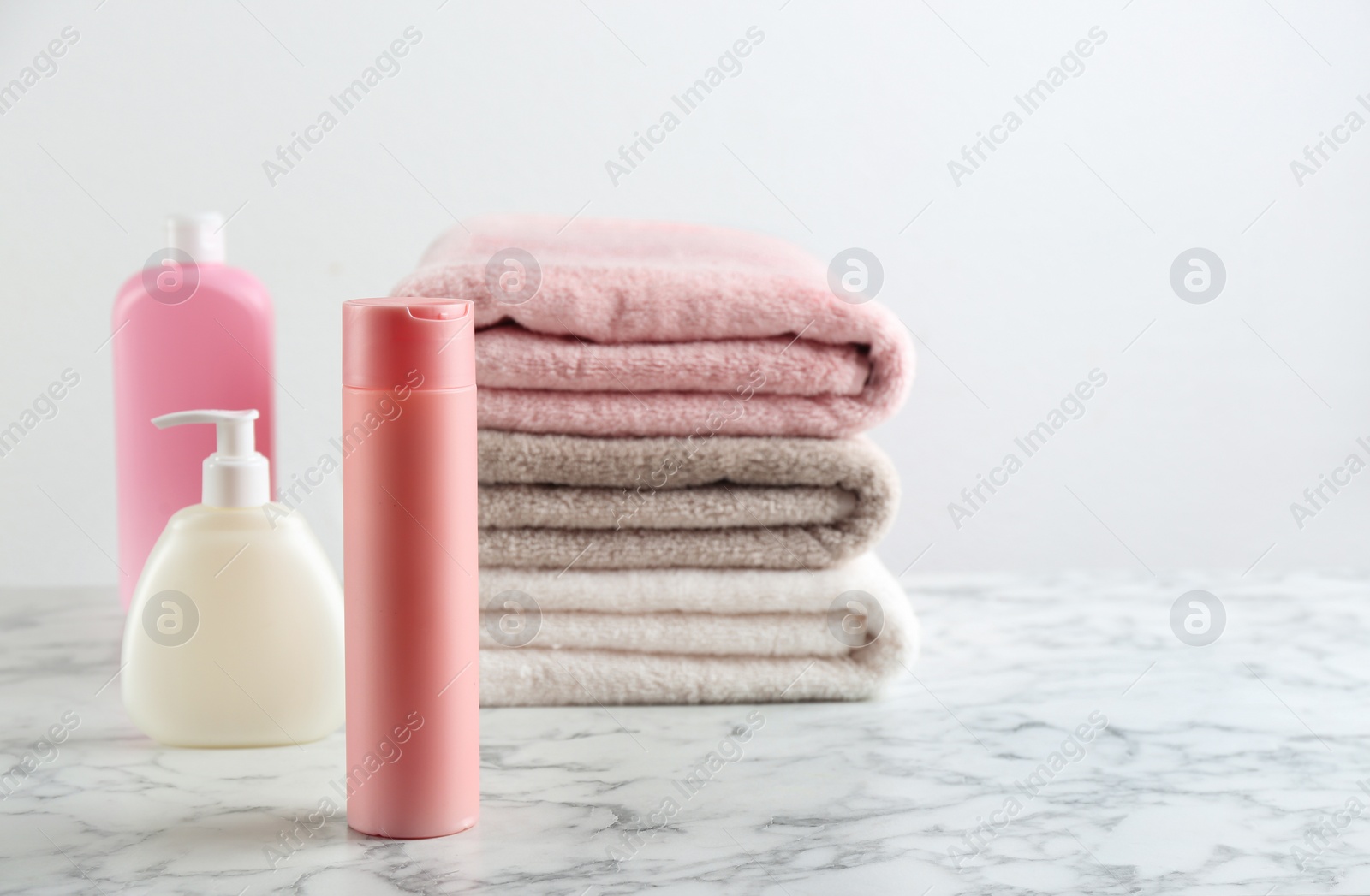 Photo of Fresh towels and toiletries on white marble table. Space for text