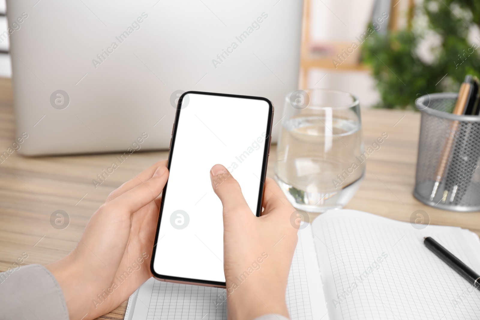 Photo of Woman with modern smartphone at wooden table, closeup