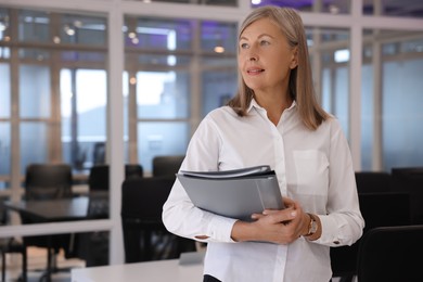 Photo of Confident woman with folders in office, space for text. Lawyer, businesswoman, accountant or manager