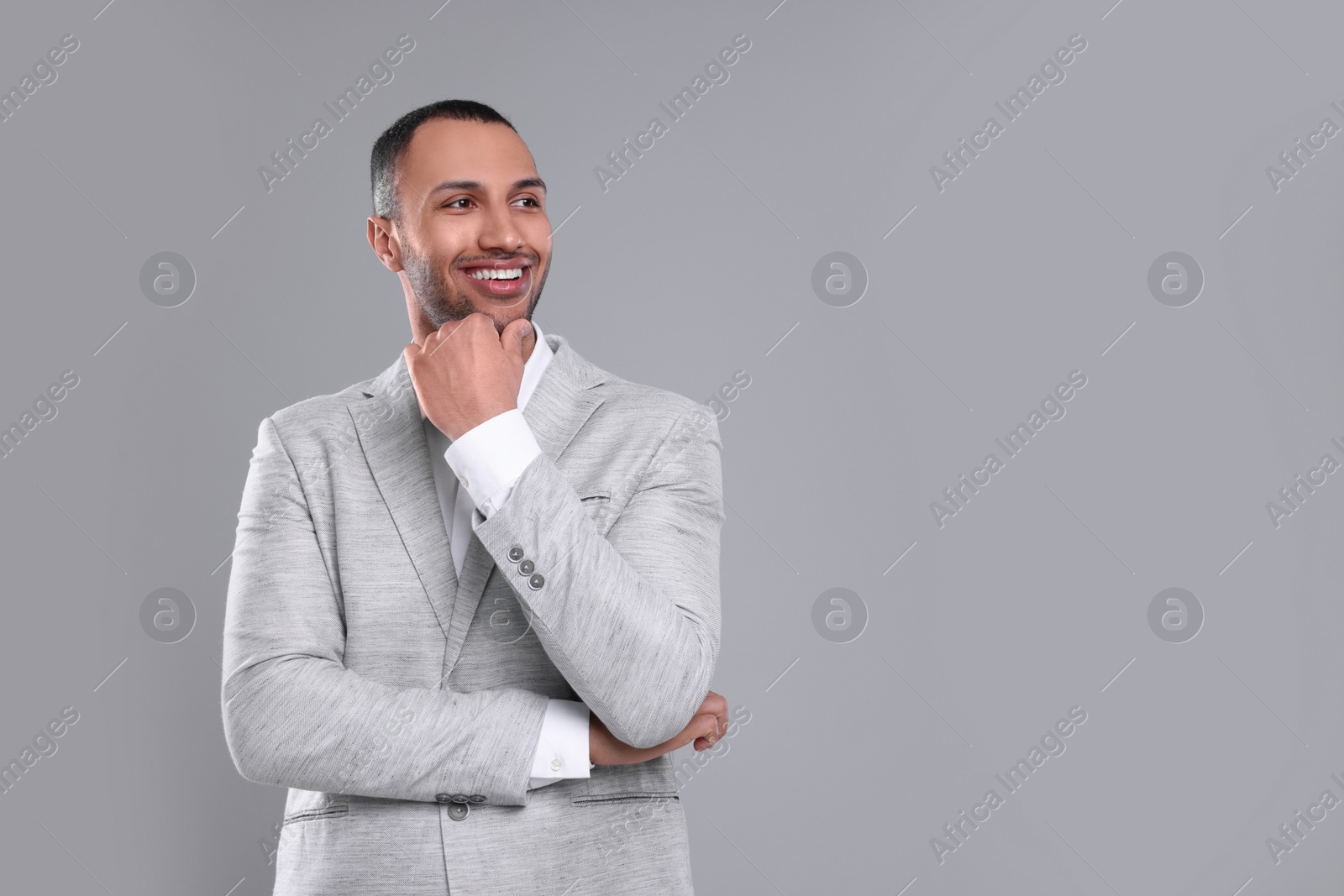 Photo of Young businessman in formal outfit on grey background. Space for text