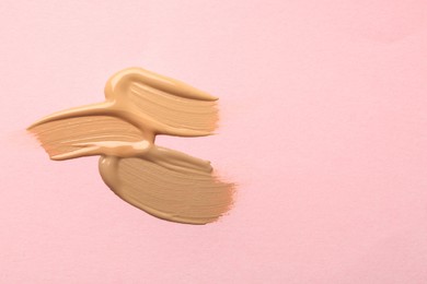 Photo of Samples of liquid skin foundation on pink background, top view. Space for text