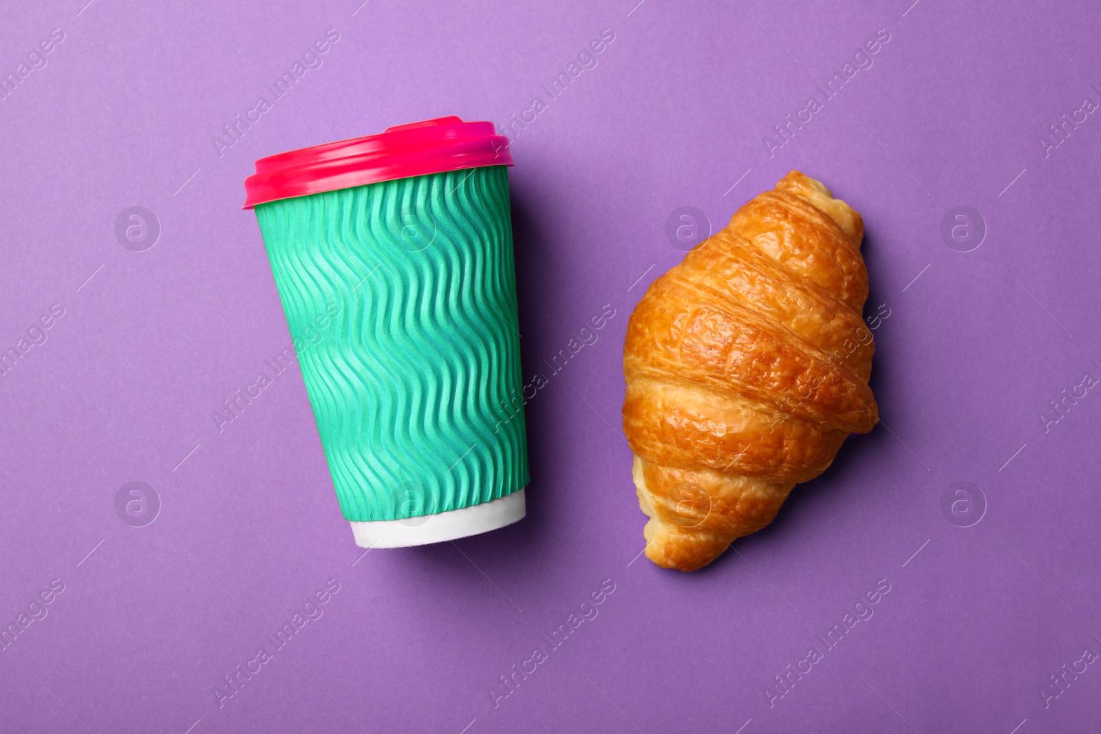 Photo of Paper coffee cup and croissant on color background, flat lay