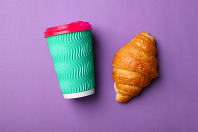 Photo of Paper coffee cup and croissant on color background, flat lay
