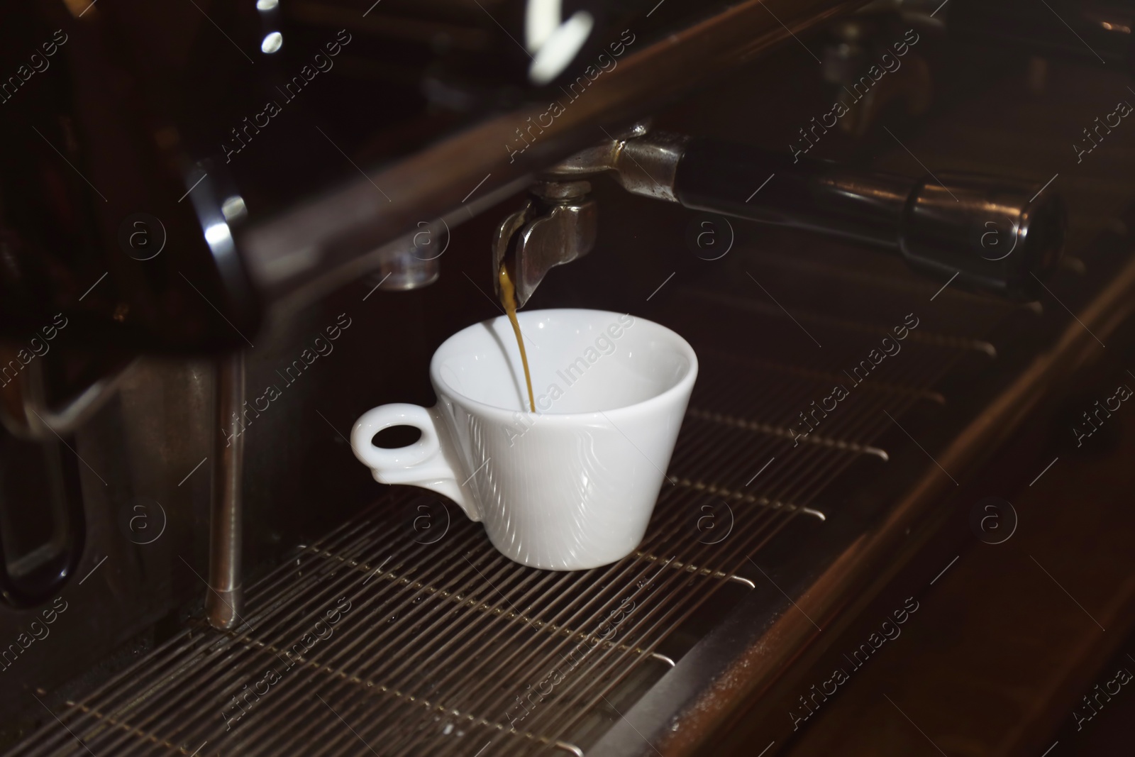 Photo of Preparing fresh aromatic coffee on modern machine, closeup