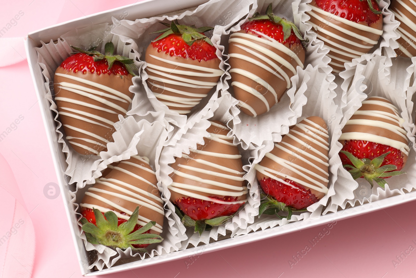 Photo of Box with delicious chocolate covered strawberries on pink background, top view