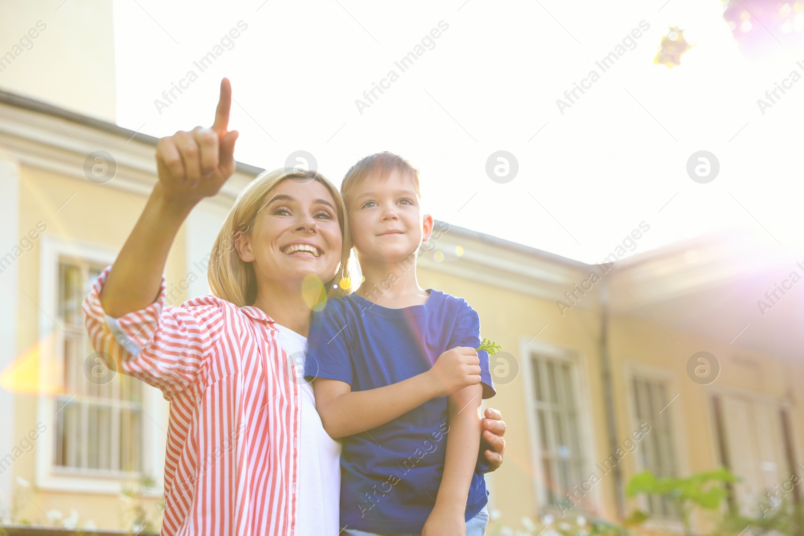 Photo of Nanny with cute little boy outdoors on sunny day, low angle view. Space for text