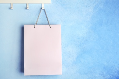 Photo of Rack with paper shopping bag on color wall. Mockup for design