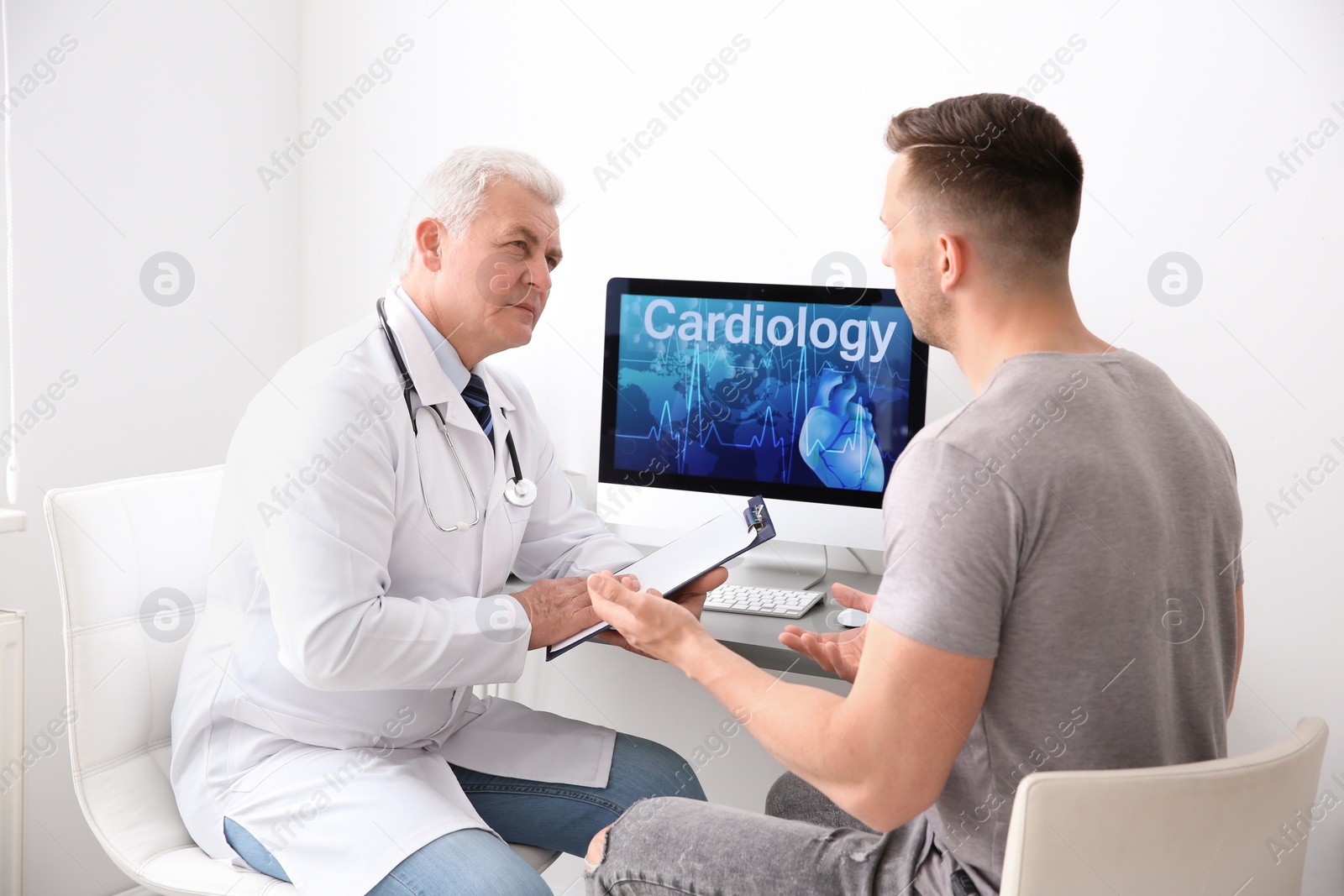 Photo of Male doctor working with patient in clinic. Cardiology consultation