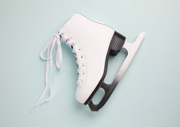 Photo of Pink ice skate on light background, top view