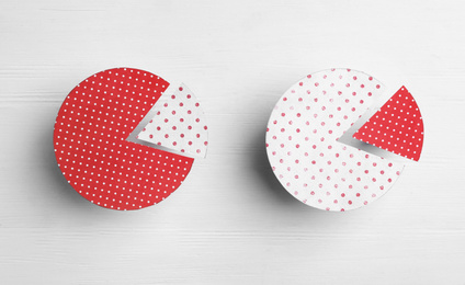 Photo of Circles with segments on white wooden background, flat lay. Pareto principle concept