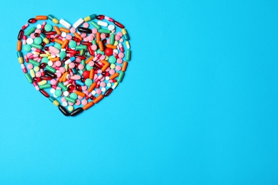 Heart made of pills on color background, top view. Space for text