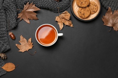 Photo of Flat lay composition with hot cozy drink and autumn leaves on dark background. Space for text