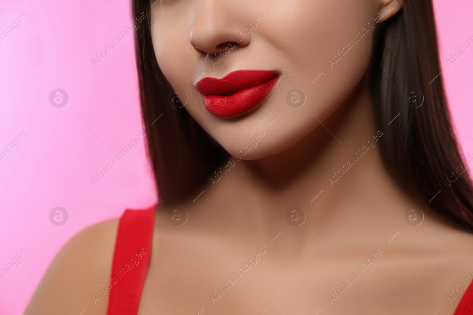 Photo of Woman with red lipstick on pink background, closeup