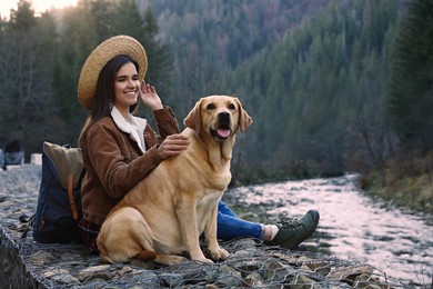 Photo of Happy woman and adorable dog in mountains. Traveling with pet