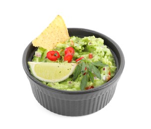 Photo of Delicious guacamole served with nachos chips, lime and pepper isolated on white