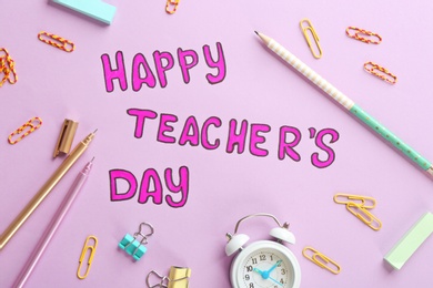 Alarm clock, text HAPPY TEACHER'S DAY and stationery on color paper