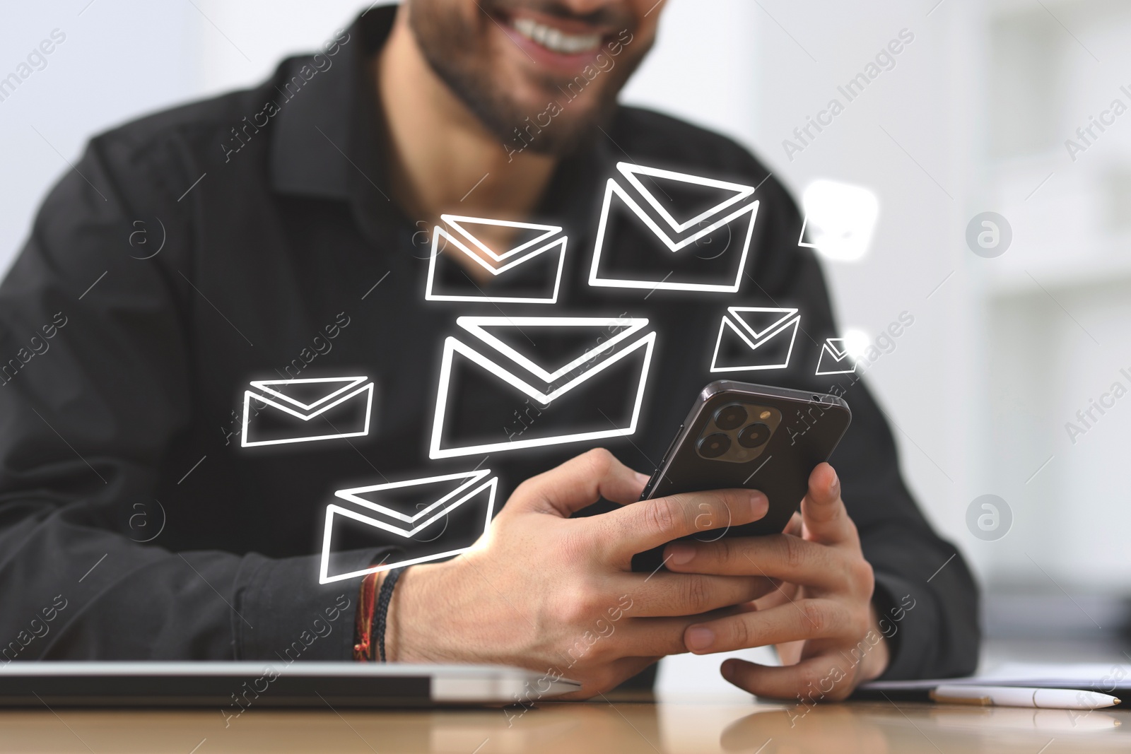 Image of Smiling man with smartphone chatting indoors, closeup. Many illustrations of envelope as incoming messages over device