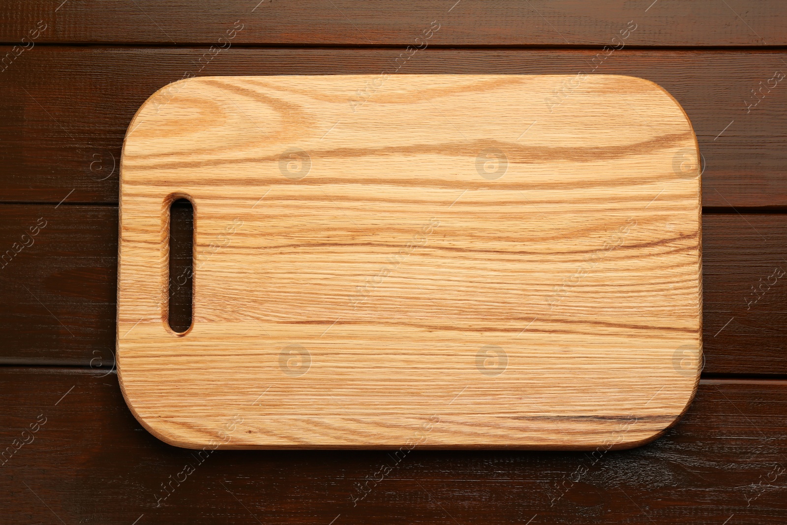 Photo of One new cutting board on wooden table, top view