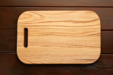 One new cutting board on wooden table, top view