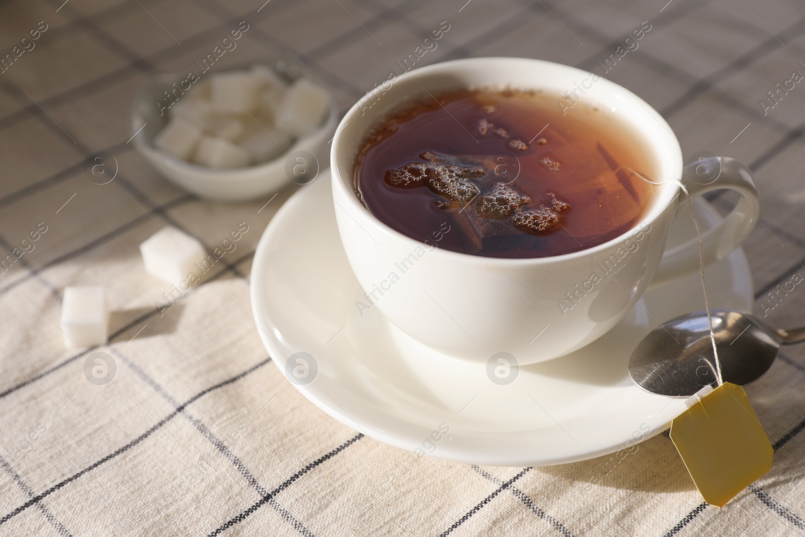 Photo of Tea bag in cup on table, closeup