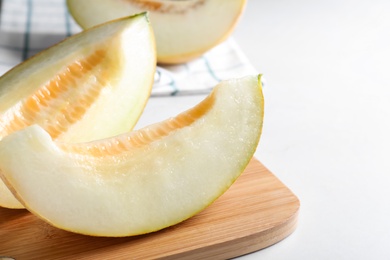 Pieces of delicious honeydew melon on white table