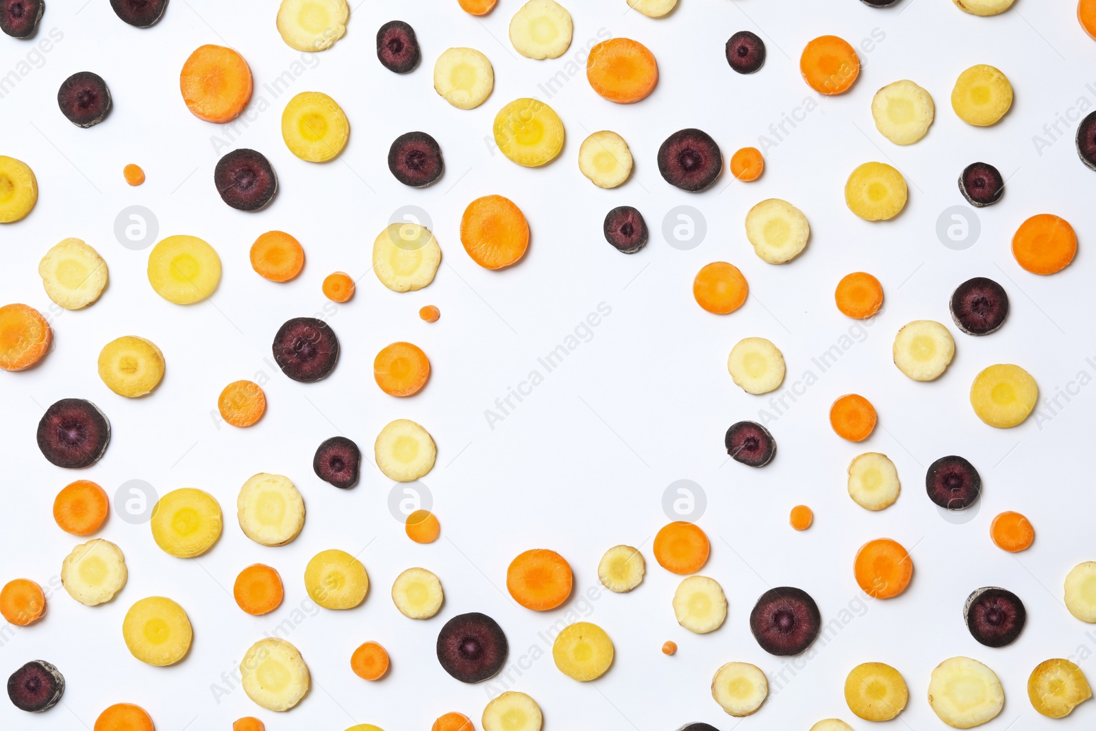 Photo of Slices of raw color carrots on white background, top view