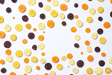 Photo of Slices of raw color carrots on white background, top view
