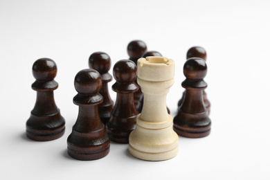Photo of White rook with black pawns on light background. Career promotion concept