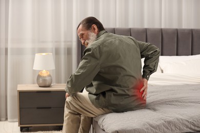Image of Senior man suffering from pain in lower back on bed at home