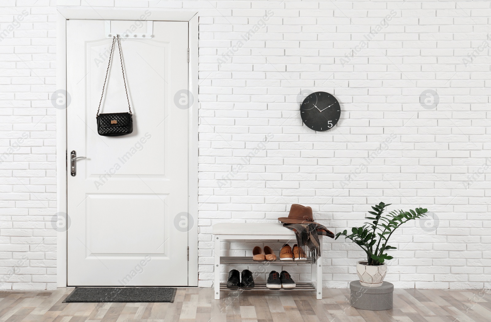 Photo of Hall interior with brick wall and white wooden door