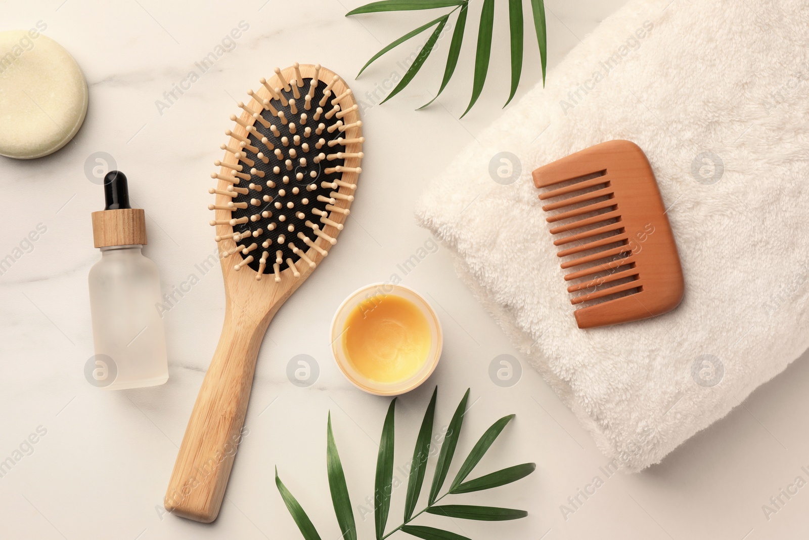 Photo of Flat lay composition with wooden hair brush and comb on white marble table