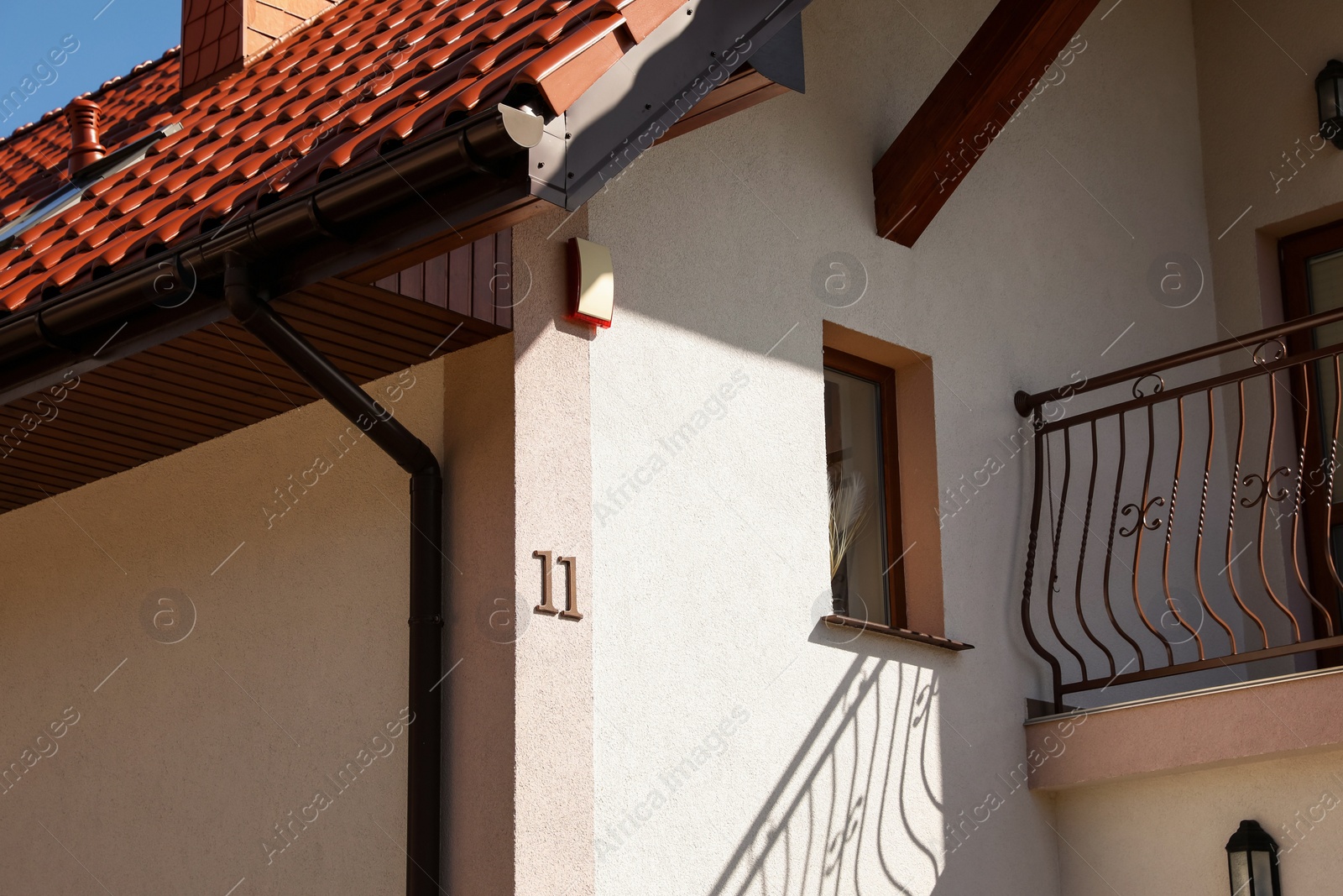 Photo of Number eleven on beige house with balcony outdoors