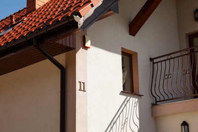 Photo of Number eleven on beige house with balcony outdoors