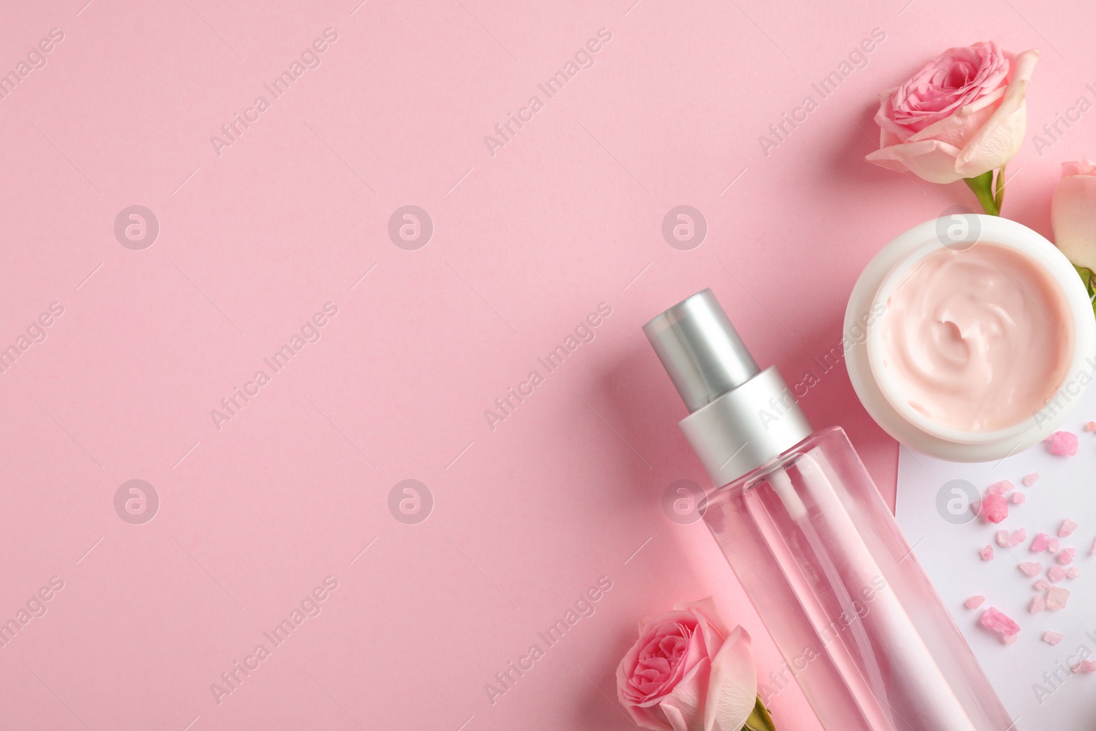 Photo of Flat lay composition with rose essential oil on color background, space for text