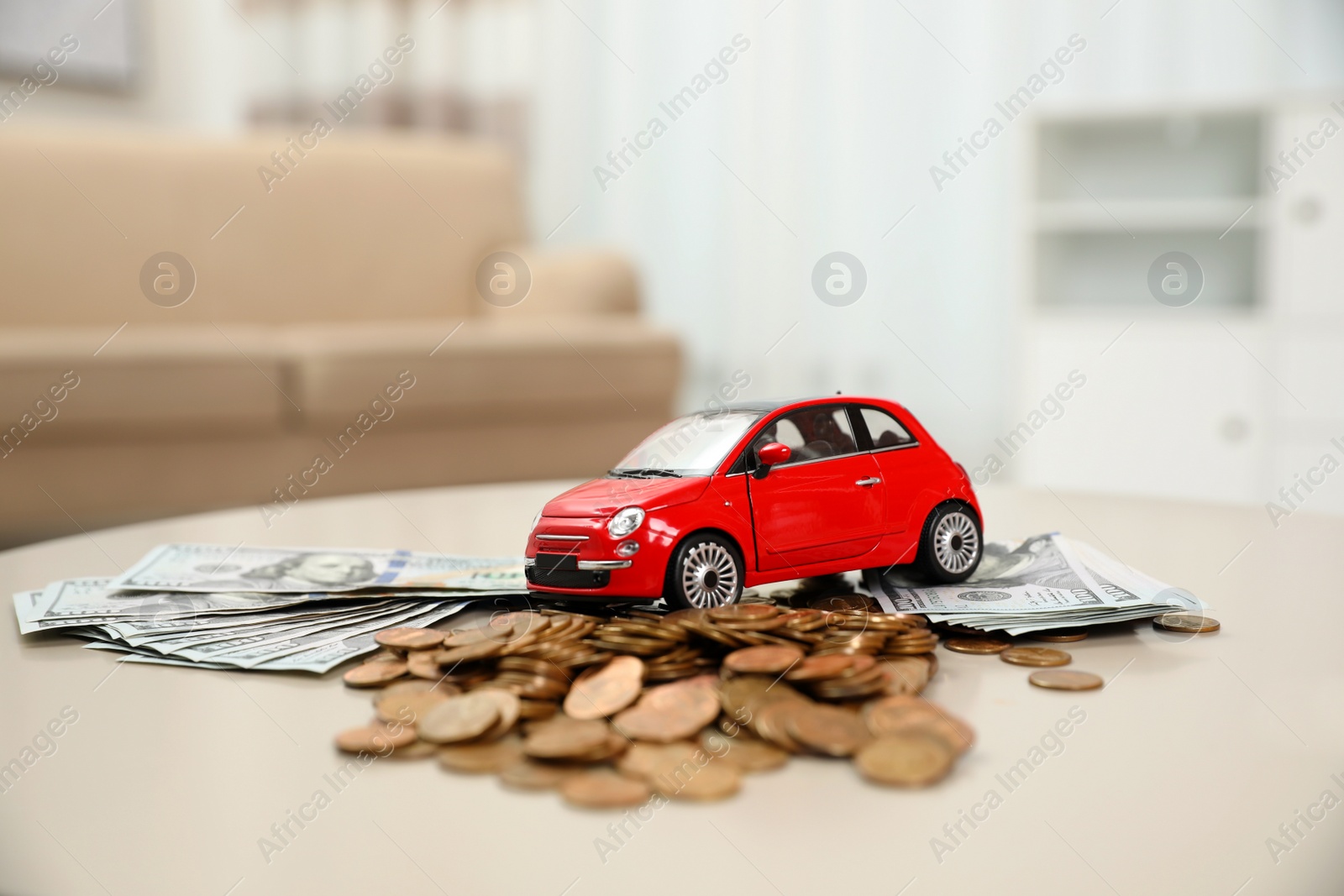 Photo of Miniature automobile model and money on table indoors. Car buying