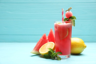 Photo of Delicious fresh watermelon drink on light blue wooden table. Space for text