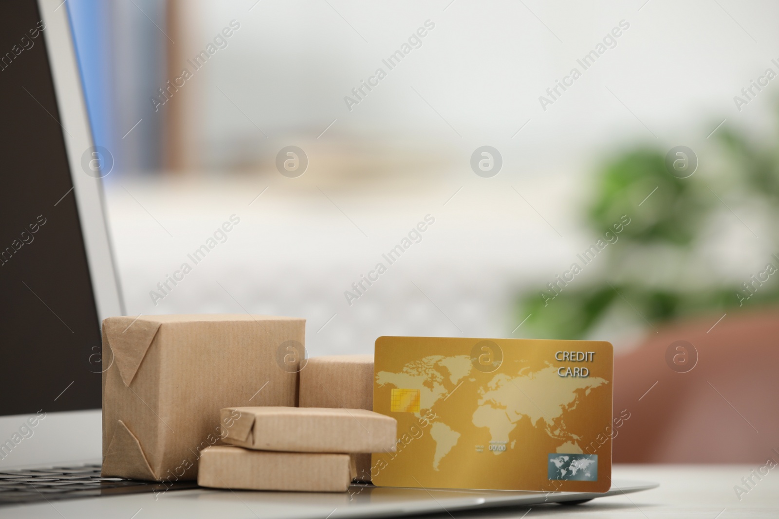 Photo of Online payment concept. Bank card and small boxes with laptop on table