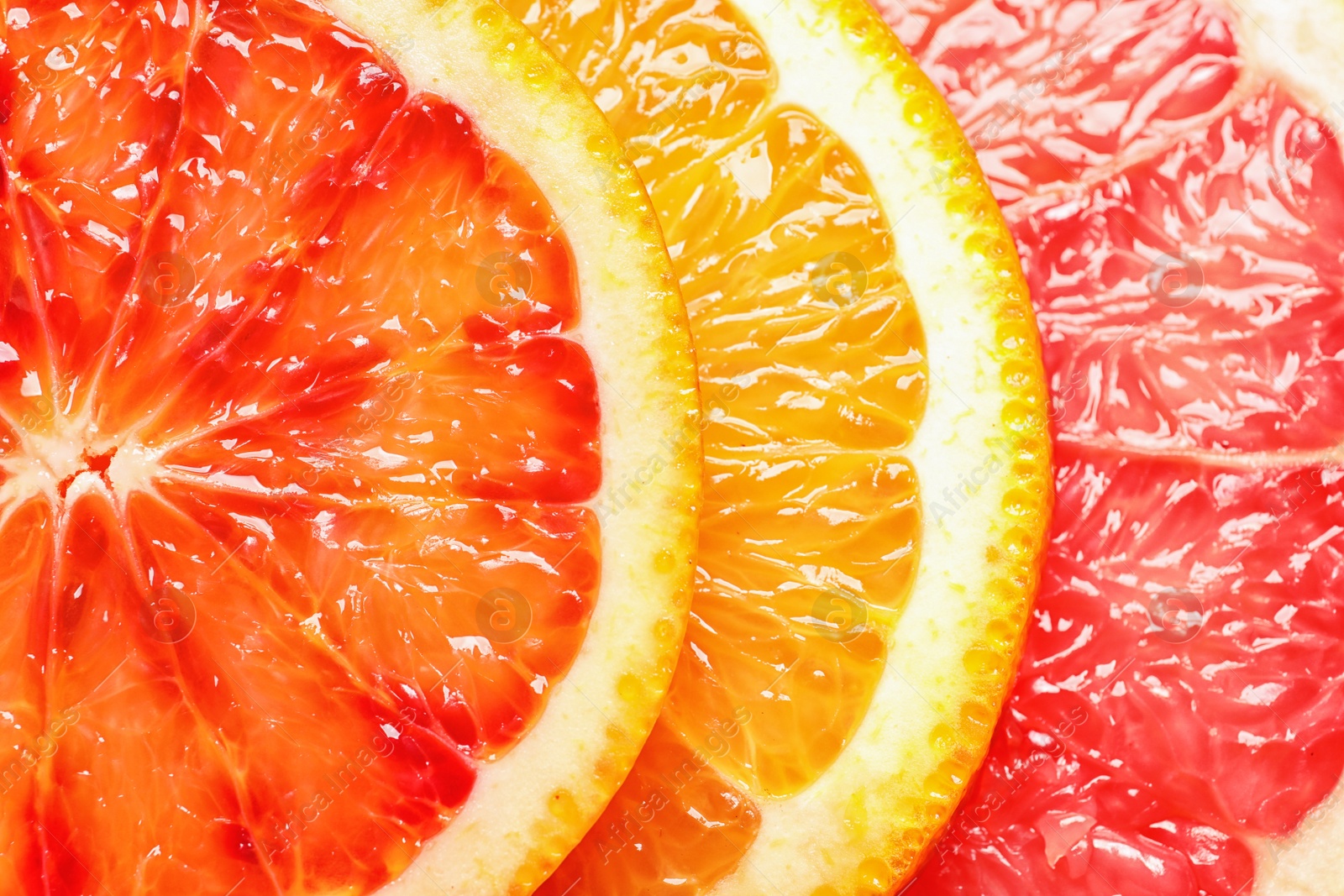 Photo of Slices of fresh citrus fruits as background, top view