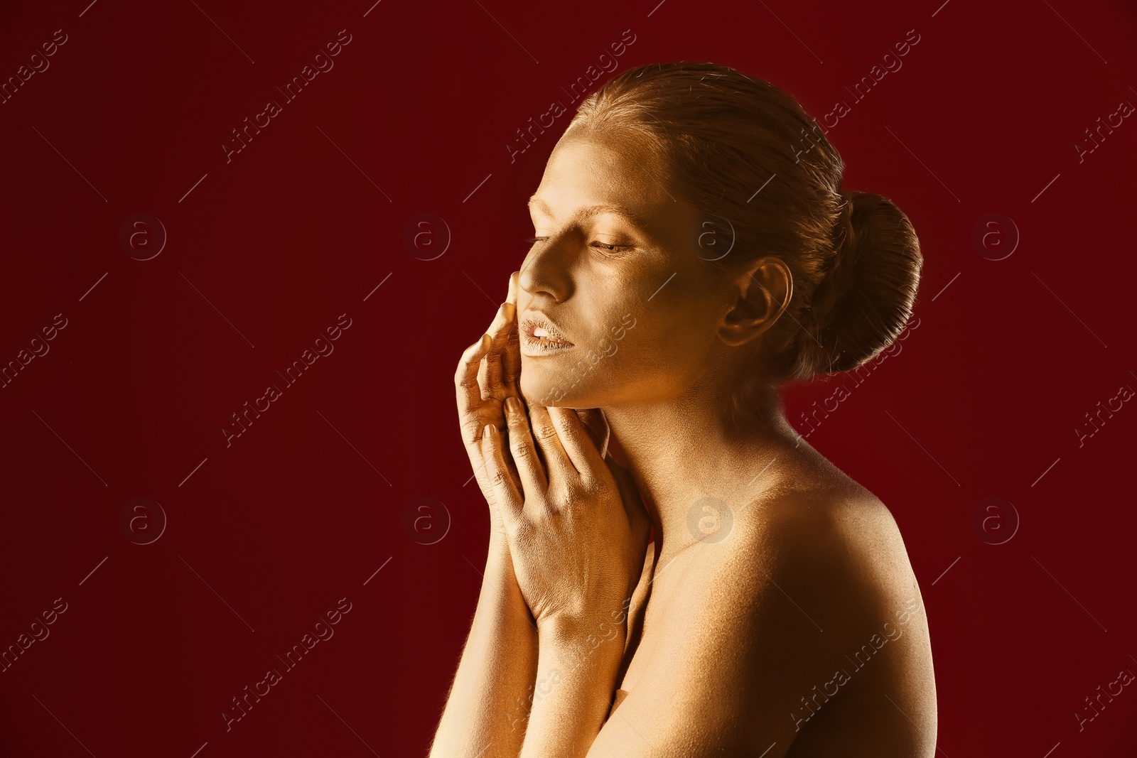 Photo of Portrait of beautiful lady with gold paint on skin against color background