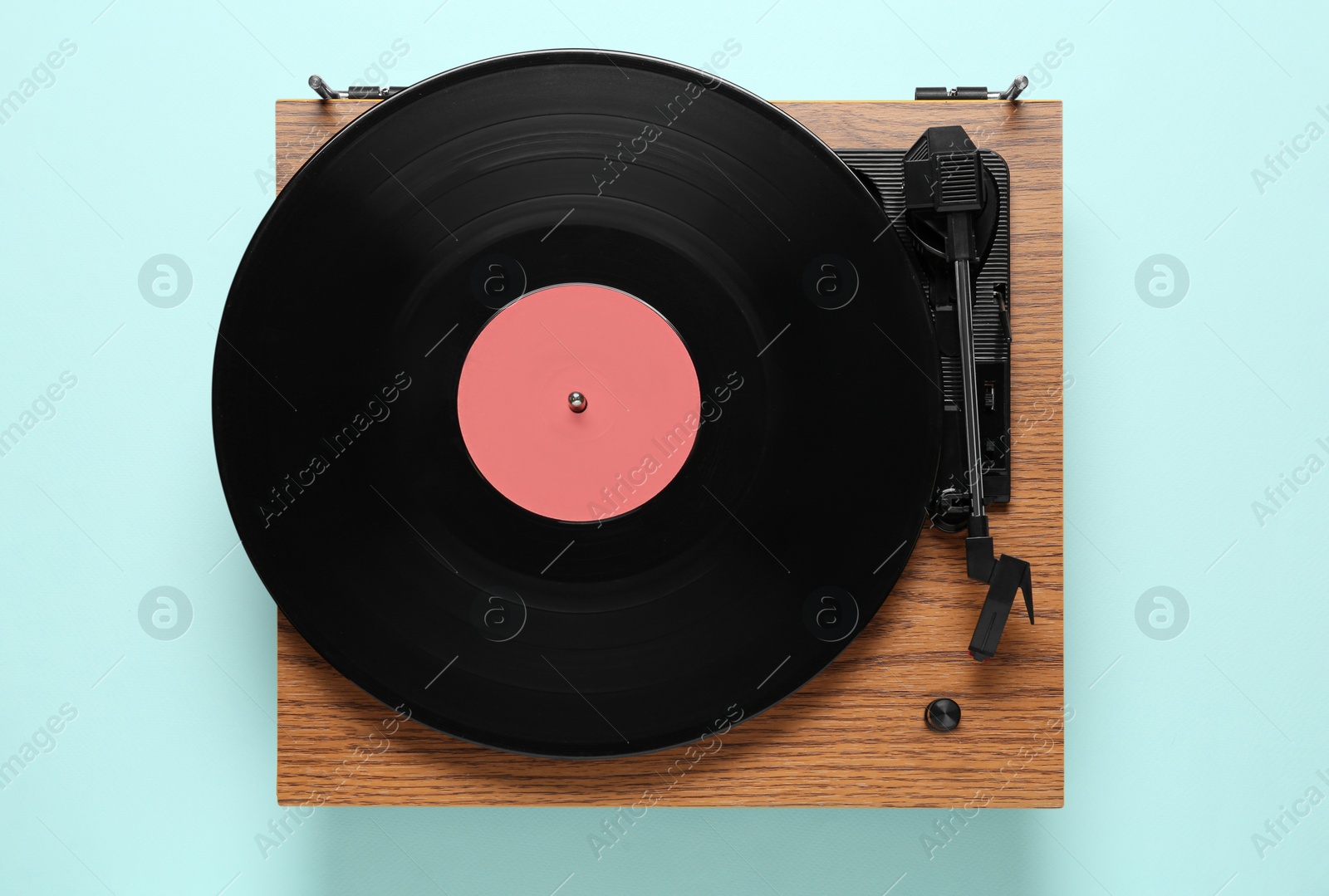 Photo of Modern turntable with vinyl record on light blue background, top view