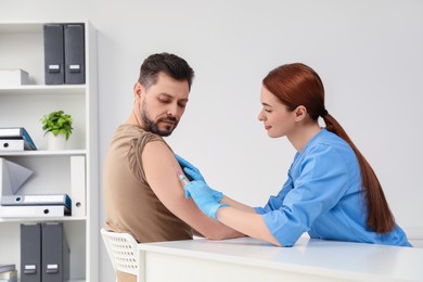 Doctor giving hepatitis vaccine to patient in clinic