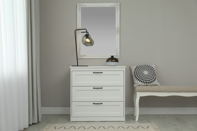 Photo of Hallway with stylish chest of drawers and mirror. Interior design